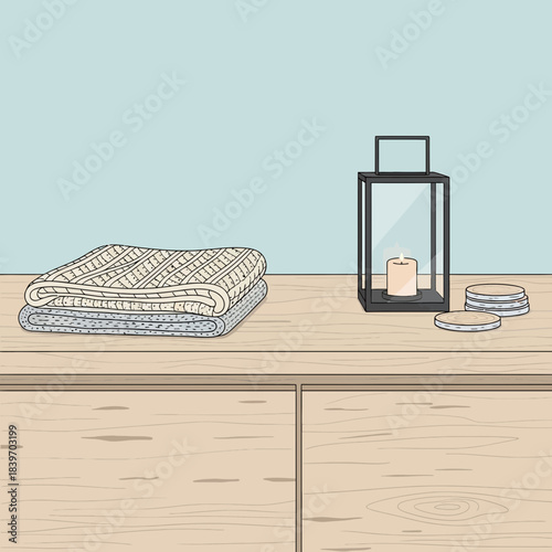 Minimalistic interior decor with neatly stacked towels and decorative lantern on wooden surface