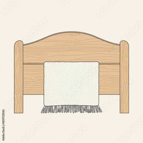 Minimalist wooden bed headboard with a white blanket draped over it showcasing simple bedroom