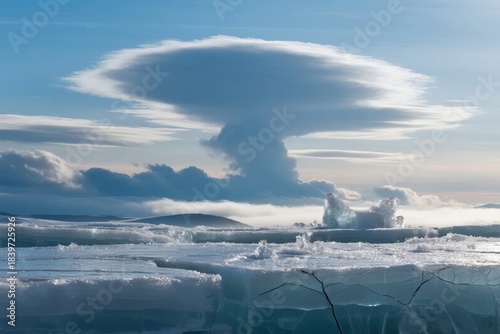 A dramatic lenticular cloud hovers over a frozen landscape with ice floes and distant snow-covered terrain under a clear blue sky.