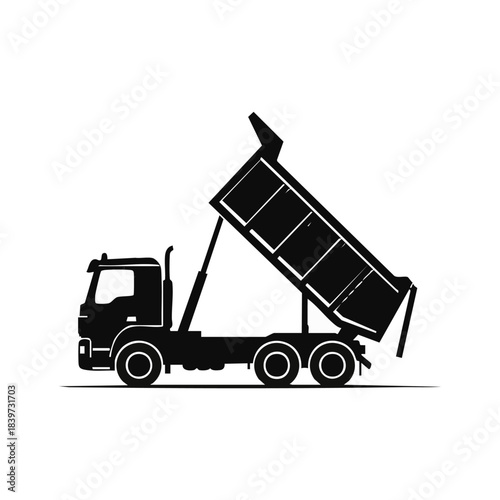 Silhouette of a dump truck unloading its cargo with raised bed.