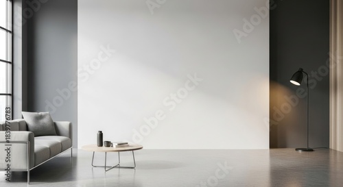 A minimalist living room with a white wall, a gray sofa, and a black floor lamp.