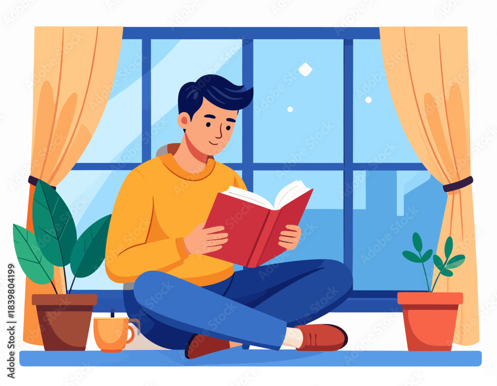 Fototapeta premium A young man reads a book peacefully on a windowsill at night. A cozy and calm moment of relaxation and learning at home.
