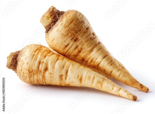 Two pale, tapering root vegetables with textured skin and rough, brown tops lie on white