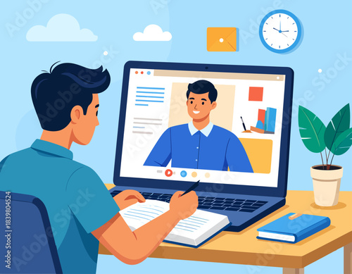 A young man attending an online class or virtual meeting on his laptop, taking notes at his desk.