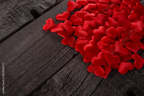 Red Hearts Scattered on Wooden Background Symbolizing Love and Passion