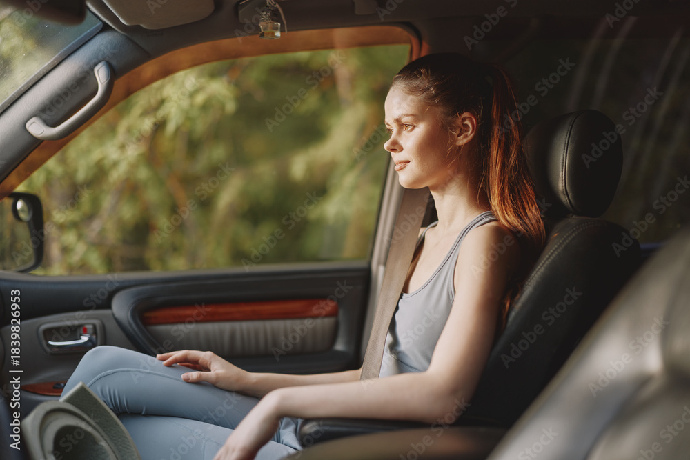 Naklejka premium A contemplative young woman in a casual outfit sits in a car, reflecting on life amidst nature s beauty, evoking tranquility and introspection