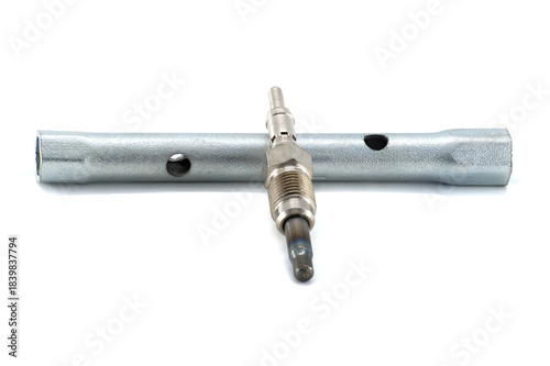 A glow plug rests on a wrench, ready for automotive maintenance, isolated against white.
