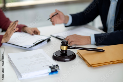 Adult legal professionals client meeting discussing important case documents justice advice at law office court room table for agreement resolution