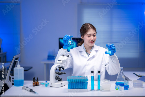 Scientist comparing two erlenmeyer flasks containing blue liquid in laboratory