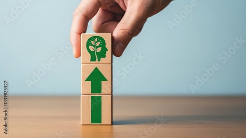 Hand stacking wooden blocks representing a growth mindset and upward progress