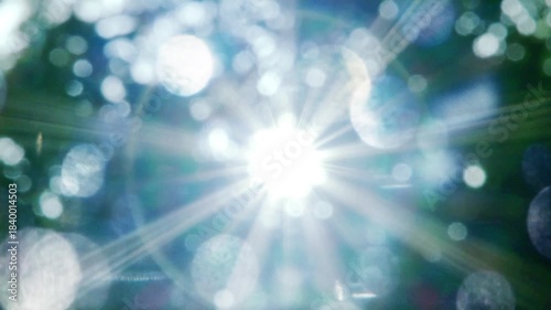 夏の太陽の暑く強い日差し　木々の葉から差し込むさわやかな木漏れ日の光とキラキラの輝く明るい丸ボケと光芒　アウトドア・季節・夏休み・日焼け・バカンス・旅行・洗濯のイメージ背景
