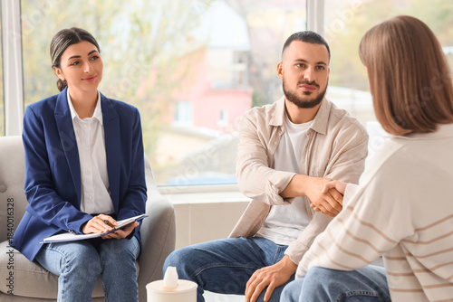 Fotografie Family mediator and young couple shaking hands in office