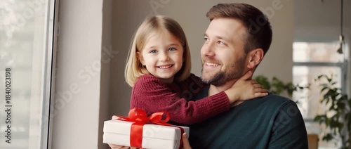 Father and Daughter with Gift: A heart-warming moment shared between a father and daughter, as the daughter embraces her father while holding a beautifully wrapped gift.