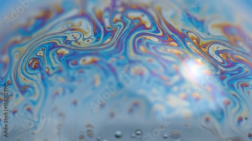 Macro Close-up of a Colorful Soap Bubble Surface with Swirling Patterns.