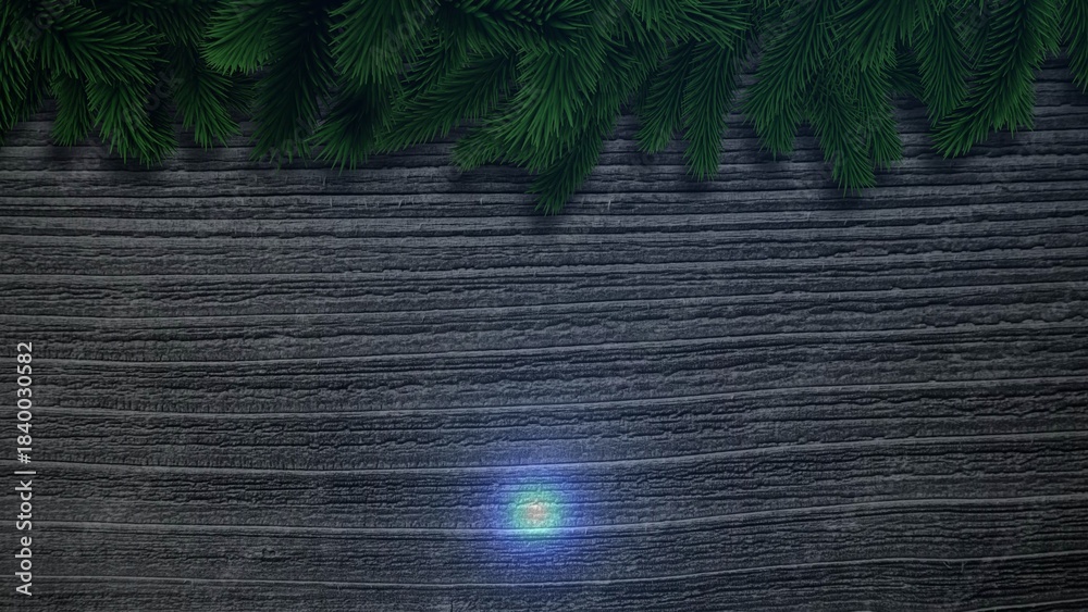 Fototapeta premium Hanging evergreen pine branches are draping across wood under teal light in flat-lay, holiday decor