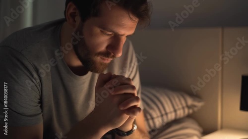 Wallpaper Mural Solemn man with beard praying in his bed at night showing deep faith and spiritual devotion during a quiet moment of reflection and worship before sleep Torontodigital.ca