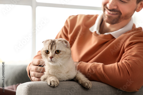 Young man petting cute Scot...