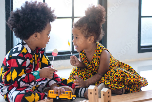 African child girl wears African cultural clothing leaned forward to discuss important matters with the boy.