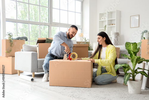 Young couple taping box in ...