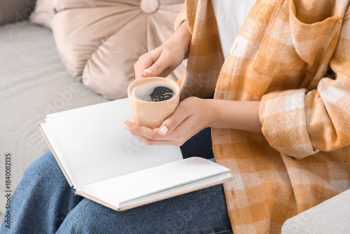 Young woman holding cup of ...