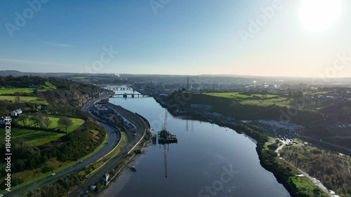 Waterford City drone view early morning cars on dual carriageway and barge on Suir River