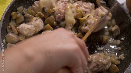 Mushrooms and tender chicken enhanced by onions cooked in pan on stove in kitchen. Simple and inviting dish for family meals or casual gatherings