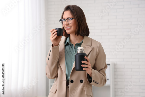 Young businesswoman drinkin...