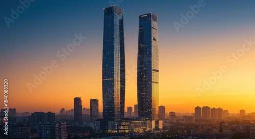 Two towering skyscrapers at sunrise over a city