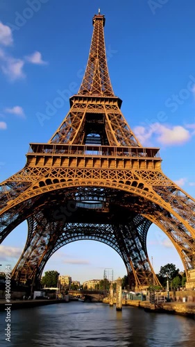 Breathtaking vertical video of Eiffel Tower at golden hour twilight, perfectly mirrored in glassy Seine River, vibrant pastel sky. Aspirational wonder concept