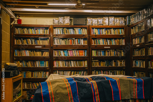 Mumbai, India Vintage library interior with old wooden bookshelves filled with worn books. A warm, nostalgic atmosphere highlighting traditional literature and classic reading spaces.