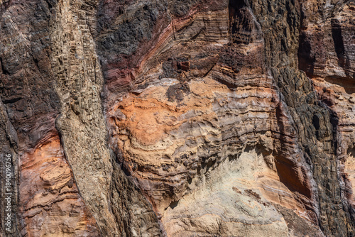 Detailed texture of volcanic cliff at Sao Lourenco Point in Madeira, showing colorful geological layers from ochre and red to black tones shaped by erosion and time