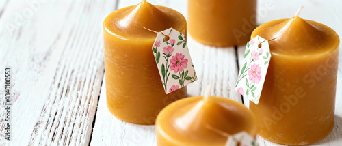 Golden candles with floral tags arranged on a wooden surface, evoking warmth and comfort