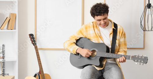 Young happy man playing gui...