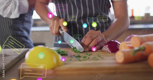 Teen girl chopping herbs with knife rhythm sparking chat icons while mom leaning helping food prep