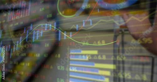 On screen load financial charts moving across display, hand holding glasses observing market trends