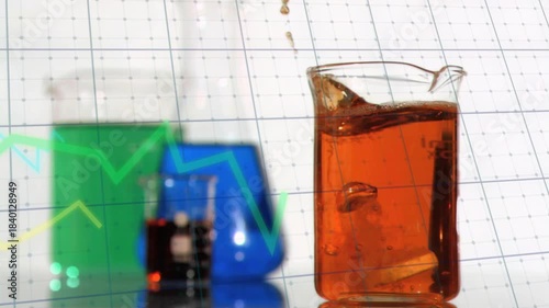 Clear glass beaker reacting to falling tablet from above, creating splashes, bubbles for demo