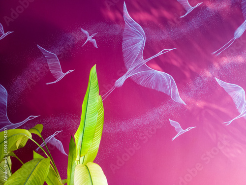 Vibrant pink wall with white birds and green tropical leaves