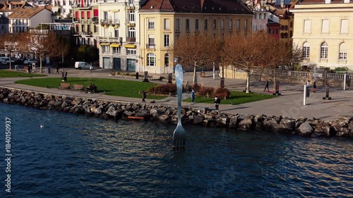 Aerial view of The Fork of Vevey plunges into the lake, reflecting the buildings and trees on Quai Perdonnet, Vaud, Switzerland.