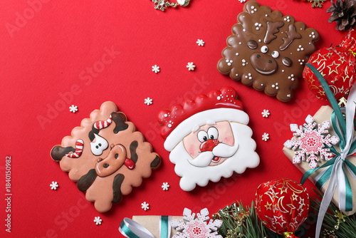 Assorted gingerbread cookies and gifts on red background. Happy New Year. Greeting card. Top view