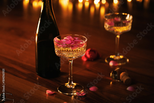A romantic setting with champagne glasses, pink rose petals, and warm golden lights, evoking love and celebration.