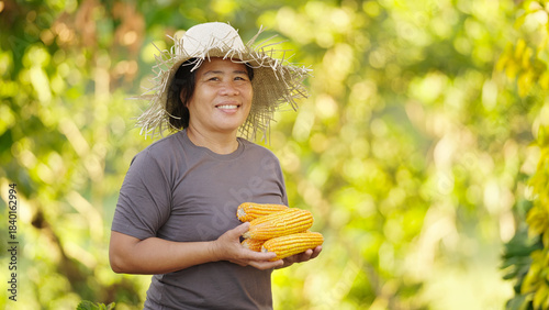 Portrait of smiling filipino woman corn farmer in the philippines, asia, wearing straw hat, looking at camera, asian