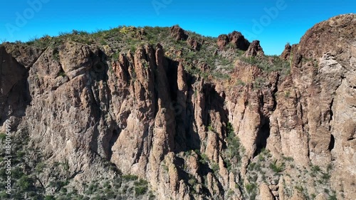 Wallpaper Mural Aerial view of rugged cliffs with textures and scattered greenery, under a clear blue sky, casting shadows, Morristown, Arizona, United States. Torontodigital.ca