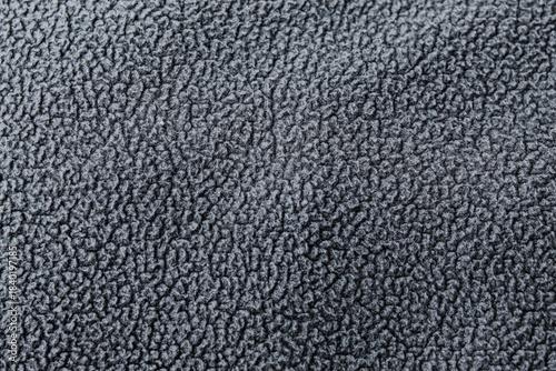 A dark gray fleece fabric with a soft, fuzzy surface. The dense, repeating fiber pattern creates a warm, cozy look.