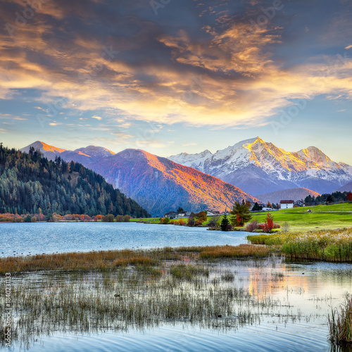 Fabulous autumn view of Haidersee (Lago della Muta) lake with Ortler peak on background.