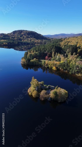 Aerial view of Loch an Eilein with autumn colours in the trees of scotland. 