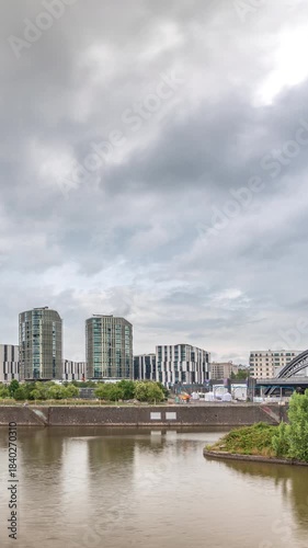 Frankfurt skyline featuring the modern ECB headquarters skyscraper with reflective steel-glass facade, train arch bridge and rainy clouds in the sky timelapse. Frankfurt am Main, Germany
