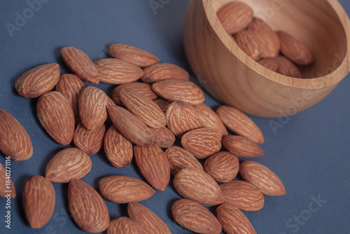 Almonds rest on a simple piece of paper, highlighting their natural texture in a clean minimal scene.