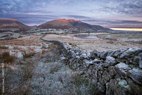View of Blencathra mountain on a cold frosty winter morning with dry stone wall. Lake District, UK.