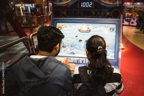 Friends enjoying arcade games together at a brightly lit indoor gaming zone.
