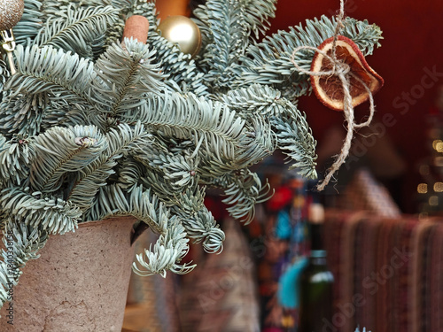 Close-up Christmas tree branches with ornaments in cozy restaurant interior.